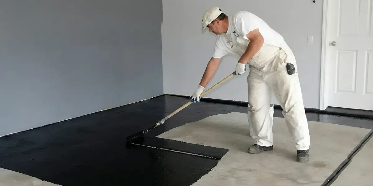 basement waterproofing professional applying waterproof coating to protect a basement floor in Allentown, PA